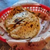 A basket containing freshly made tortillas, showcasing their grilled texture.