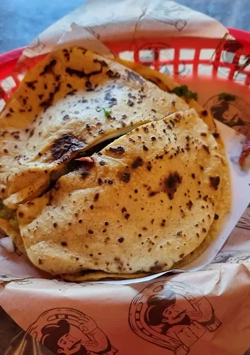 A basket containing freshly made tortillas, showcasing their grilled texture.