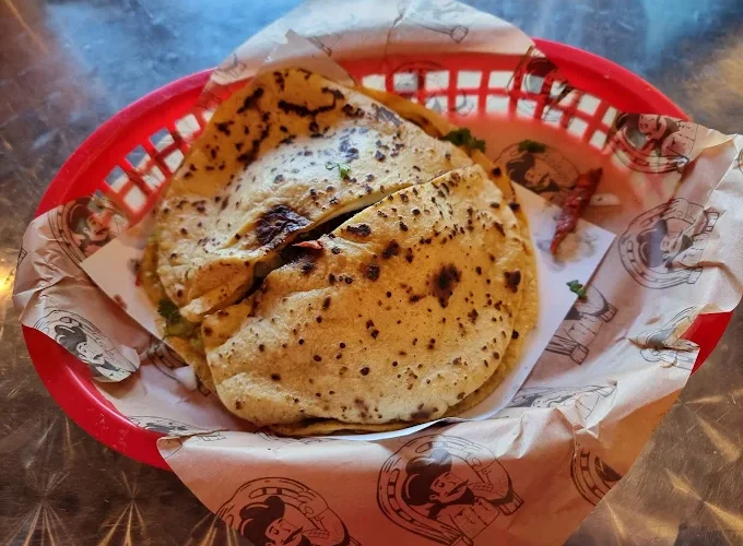 A basket containing freshly made tortillas, showcasing their grilled texture.
