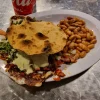 Tostada dish at Tijuanazo Hipodromo, served with seasoned meat, toppings, and a side of beans.