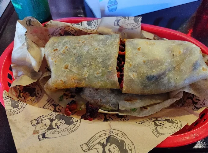 A flavorful burrito at Tijuanazo Hipodromo, showcasing a soft tortilla stuffed with seasoned meat and fillings.