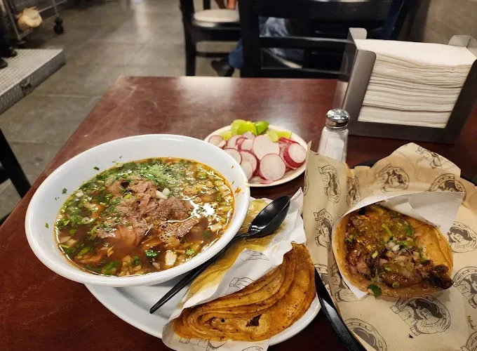 Beef soup dinner at Tijuanazo Hipodromo, accompanied by radishes and a taco.