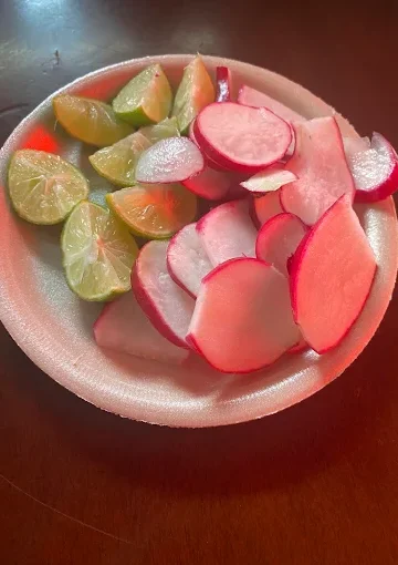 Sliced radishes and lime wedges at Tijuanazo Hipodromo, served as a fresh accompaniment.