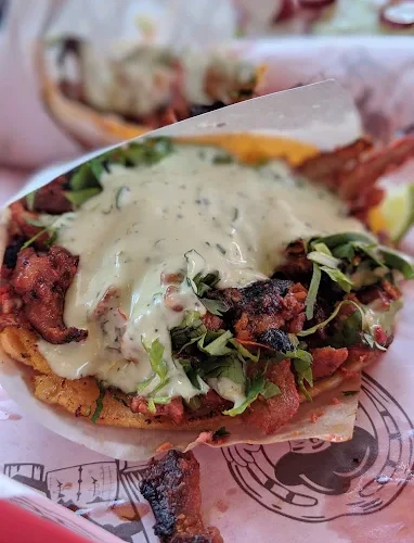 A flavorful taco at Tijuanazo Hipodromo, topped with grilled meat, cilantro, and creamy green sauce.