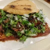 A crispy taco at Tijuanazo Hipodromo, loaded with meat, cilantro, and onions.