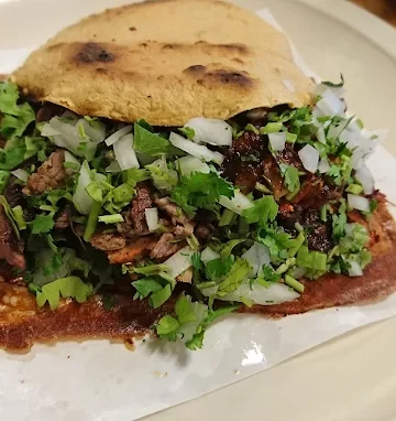 A crispy taco at Tijuanazo Hipodromo, loaded with meat, cilantro, and onions.