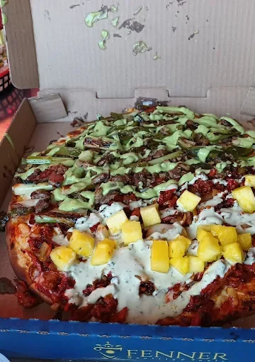 Takeout pizza at Tijuanazo Hipodromo, featuring a mix of toppings including meat and avocado.