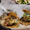 Tacos at Tijuanazo Hipodromo, featuring flavorful fillings and vibrant toppings, with lime on the side.